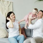 Photo of a Couple Sitting With a Baby